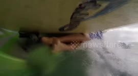 Stand up paddle boarder passes over canoeist