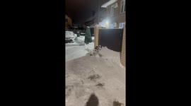 Child falls asleep on snow while father clears nearby area in Kazan, Russia
