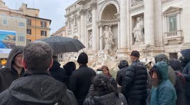 In the background is the Trevi Fountain as citizens and tourists with umbrellas watch the inauguration of the Trevi Fountain and subsequent cleaning work for the Jubilee on a rainy December day in Rome.