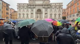 In the background is the Trevi Fountain as citizens and tourists with umbrellas watch the inauguration of the Trevi Fountain and subsequent cleaning work for the Jubilee on a rainy December day in Rome.