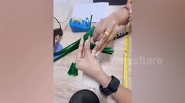 Girl turns paper and fuzzy wires into homemade Christmas tree