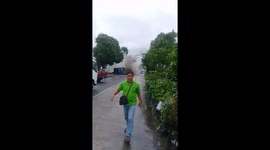Sand-laden truck flips over and catches fire