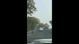 Sacks of peanuts fall from truck in India