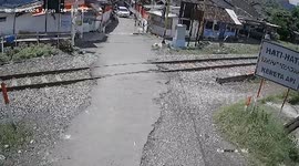 Car hit by train while driver manoeuvers over level crossing in Indonesia