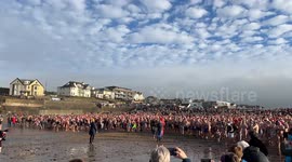 Over a thousand people crowd the beach at Bude in Cornwall before running into the Sea for the Christmas swim