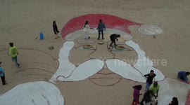 Artist makes giant Santa Claus sand art mural in India