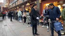 Harrods staff serve cake and coffee to customers waiting in line for the store's opening on Boxing Day in London