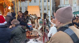 Adults and children enjoy the carousel in Piazza Navona on Christmas Day in Rome.