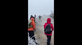 Hiker slips and slides down icy mountain road in China