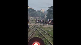 People on railway tracks as train approaches in Mymensingh, Bangladesh
