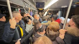 People in winter clothes crammed inside a packed bus on the move in Rome.
