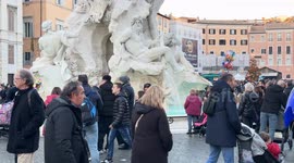 People walking around the Fountain of the Four Rivers recently restored for the Jubilee in Rome.