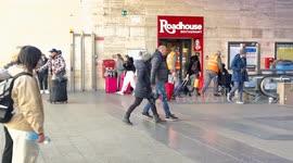 Travelers wait to catch a train at Termini Station and timetables show delays on some trains departing and arriving on New Year’s Day in Rome.