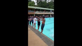 Holidaymakers perform playful domino dive stunt at pool