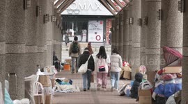 The gathering place for homeless people around Longshan Temple in Taipei creates a stark contrast when female students pass by.