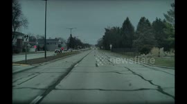A white car does a burnout while crossing traffic in West Allis, Wisconsin