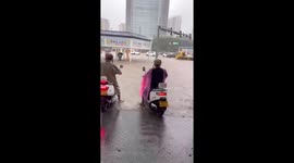 Scooter riders power their way through flooded road in China