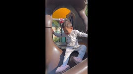 Toddler's hair stands up like Einstein from static on park slide