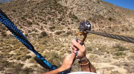 Sportsman ziplining POV aerial view of sportsman in zipline amidst mountain in Murcia, Spain