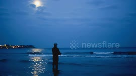 Fisherman catch fish at night against moon light