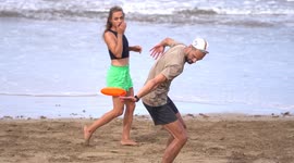 Maspalomas Spain - January 2 2024: Frisbee tricks at the beach. People  play and do tricks with frisbee in slowmotion.