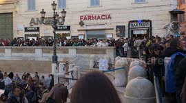 Tourists accessing the Trevi Fountain guided by security personnel who regulate visitor access to the area in front of the Trevi Fountain in Rome.
