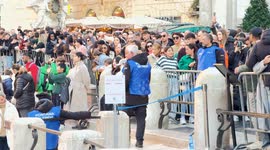 Security men monitor what tourists are doing in the area in front of the Trevi Fountain in Rome.