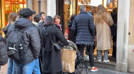 People line up to enter a store on the opening day of the winter sales in Rome.