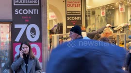 People in a clothing store promising various discounts of up to 90% on the opening day of the winter sales in Rome.