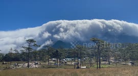 Clouds flow over mountain like a waterfall