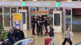 Three Carabinieri speak to two people during checks at the Termini Station in Rome.