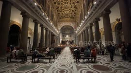 Wide shot of the interior of the church of Santa Maria in Trastevere with some people inside during the Christmas period in Rome.