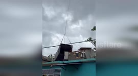 Helicopter lifts container to prevent collapse onto homes in Mayotte