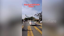 Car drives aggressively through crowd of bikes nearly crashing into them