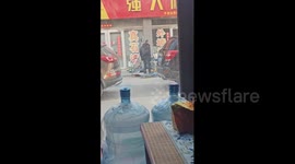 Playful pensioner stands on warehouse trolley like a skateboard