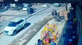 Fallen motorcycle rider narrowly avoids being crushed by truck wheels