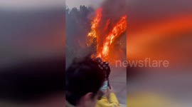 Palisades Fire burns hillside in front of news crews in LA