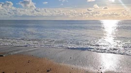 A beautiful, sunny january winter day at the iconic West Bay, Jurassic Coast, Dorset, UK. The sand, the ocean and the clifs were lit by the sun, a perfect day for a promenade along the Jurassic Coast.