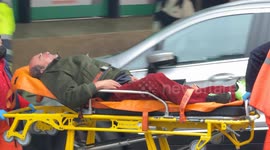 Emergency medical personnel pick up and carry away a drunk person outside Termini Station in Rome.
