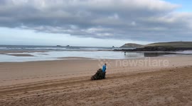 Volunteers recycling Christmas trees by planting them in the sand dunes at Constantine beach, Cornwall, UK