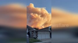 Palisades Fire orange smoke rises above homes in San Fernando Valley