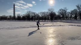 Ice hockey player skates across frozen lake in Washington, DC