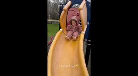 Little girl slid down the slide and tumbled at the bottom