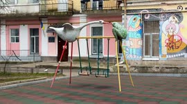 An empty swing rocks on a playground as air raid sirens sound in Kyiv, Ukraine