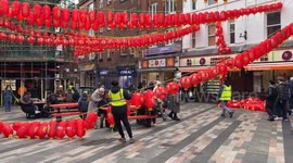 Workers install new red lanterns in London's Chinatown, ahead of Chinese New Year, marking the Year of the Snake