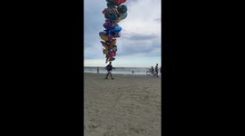 Balloon Salesman Walks Beach