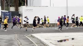 People run under the words ‘sport and health’ that appear on a wall during the ‘Miguel's Run’ in Rome.