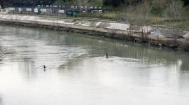People row their canoes along the Tiber on a Sunday morning in January in Rome.