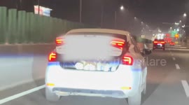 Boot of moving vehicle opens to reveal three huskies hitching a ride