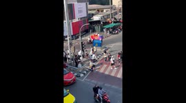 Panda mascots dance as they cross busy road in Bangkok